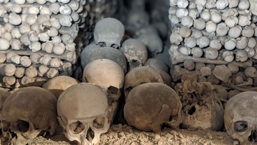 Dusty skulls and bones stacked in the corner of the Bone Church