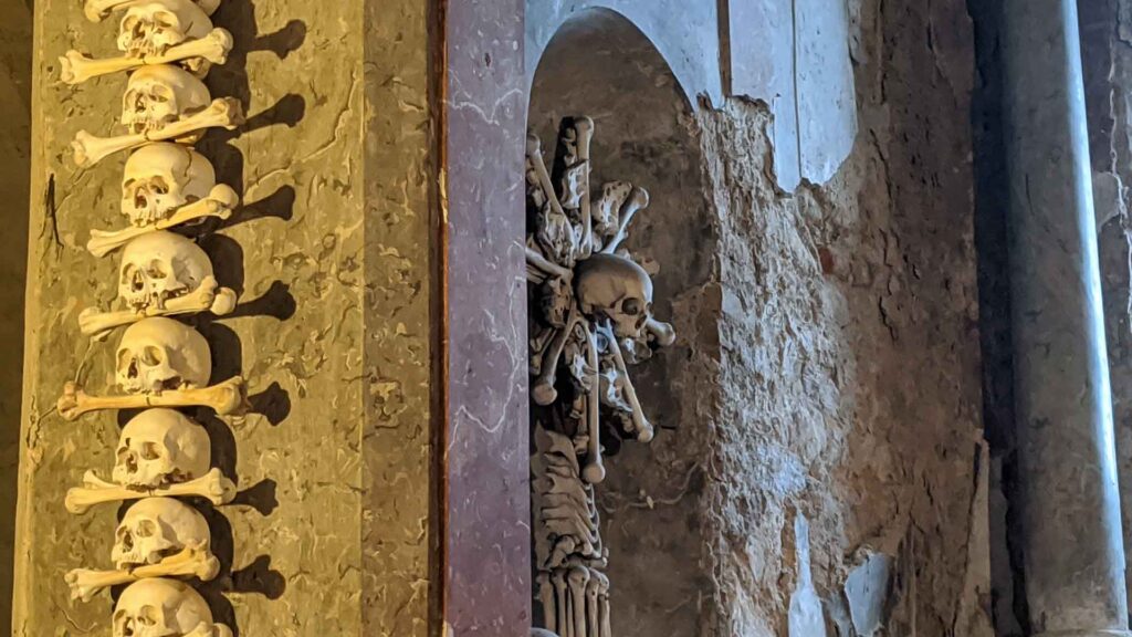 Photo of creepy wall coverings of skulls and bones at the Sedlec Ossuary Bone Church