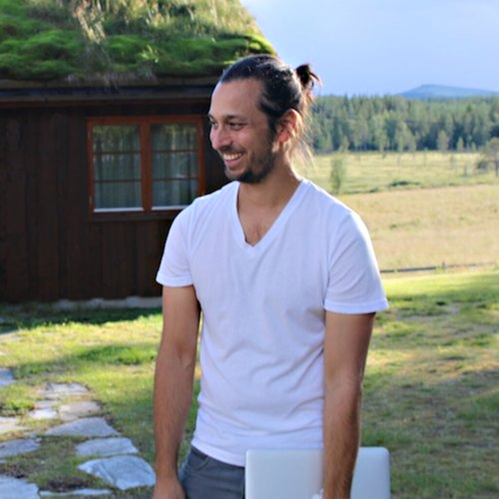 Jason Moore the podcaster in a white t-shirt holding a laptop