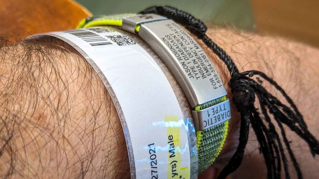 Hand wearing Road ID bracelet with hospital admittance bracelet