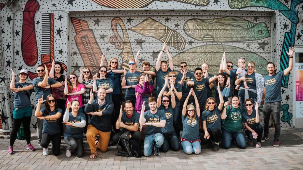 Group of location indie community members holding up arms