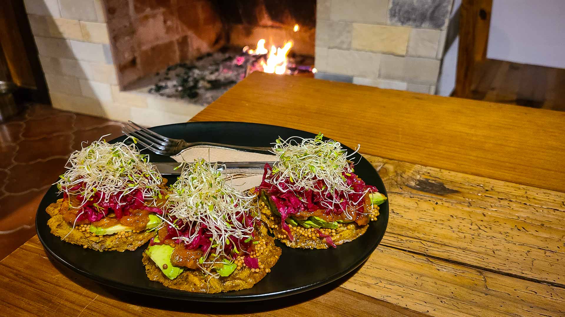 a plate of food with bean sprouts on top in front of an indoor fireplace.